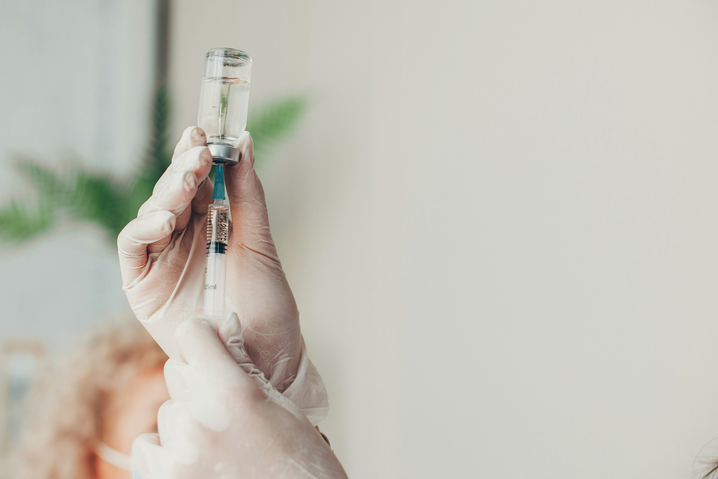 An image of a needle being inserted into a bottle of medication